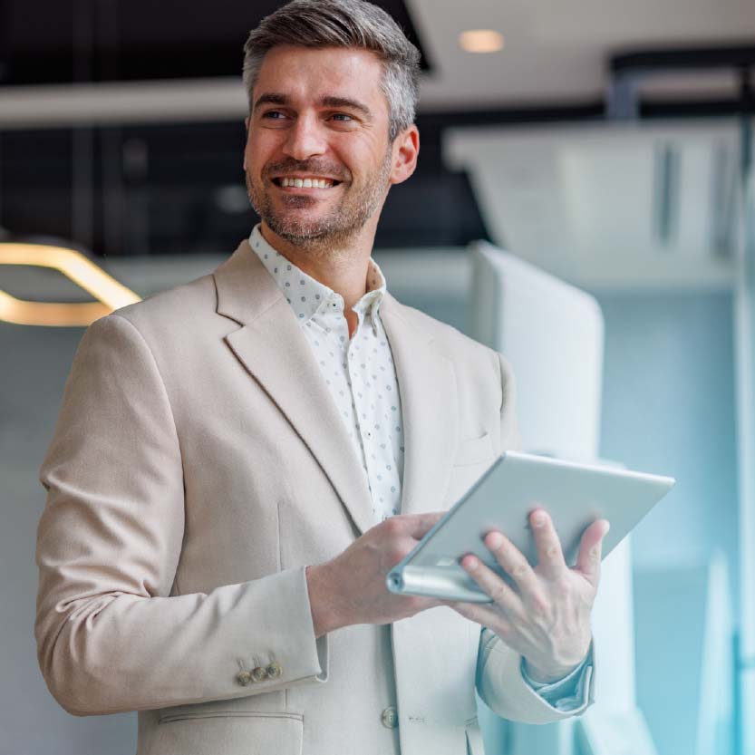 Profissional de atendimento sorrindo com um tablet em ambiente corporativo