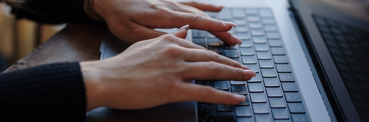 Duas mãos digitando no teclado de um notebook